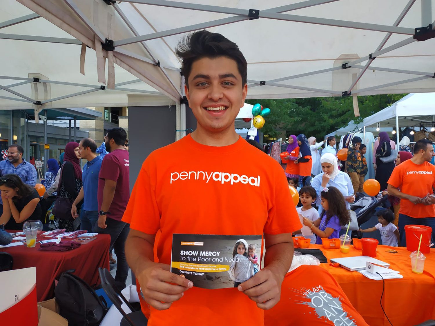 Team Orange volunteer working at Penny Appeal Canada's booth