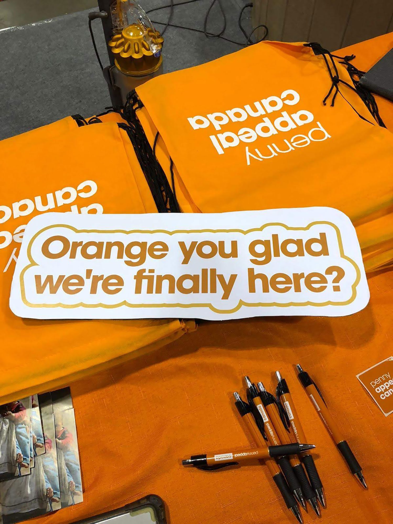 Team Orange merchandise, including sign reading 'Orange you glad we're finally here?'