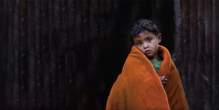 Child wrapped in an orange blanket